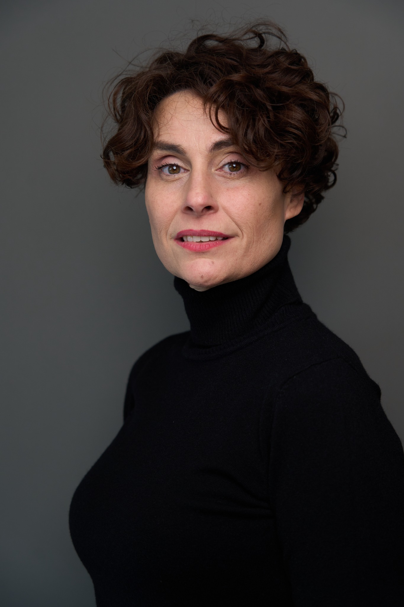 Retrato de casting de Begoña Álvarez con jersey negro y cabello rizado
