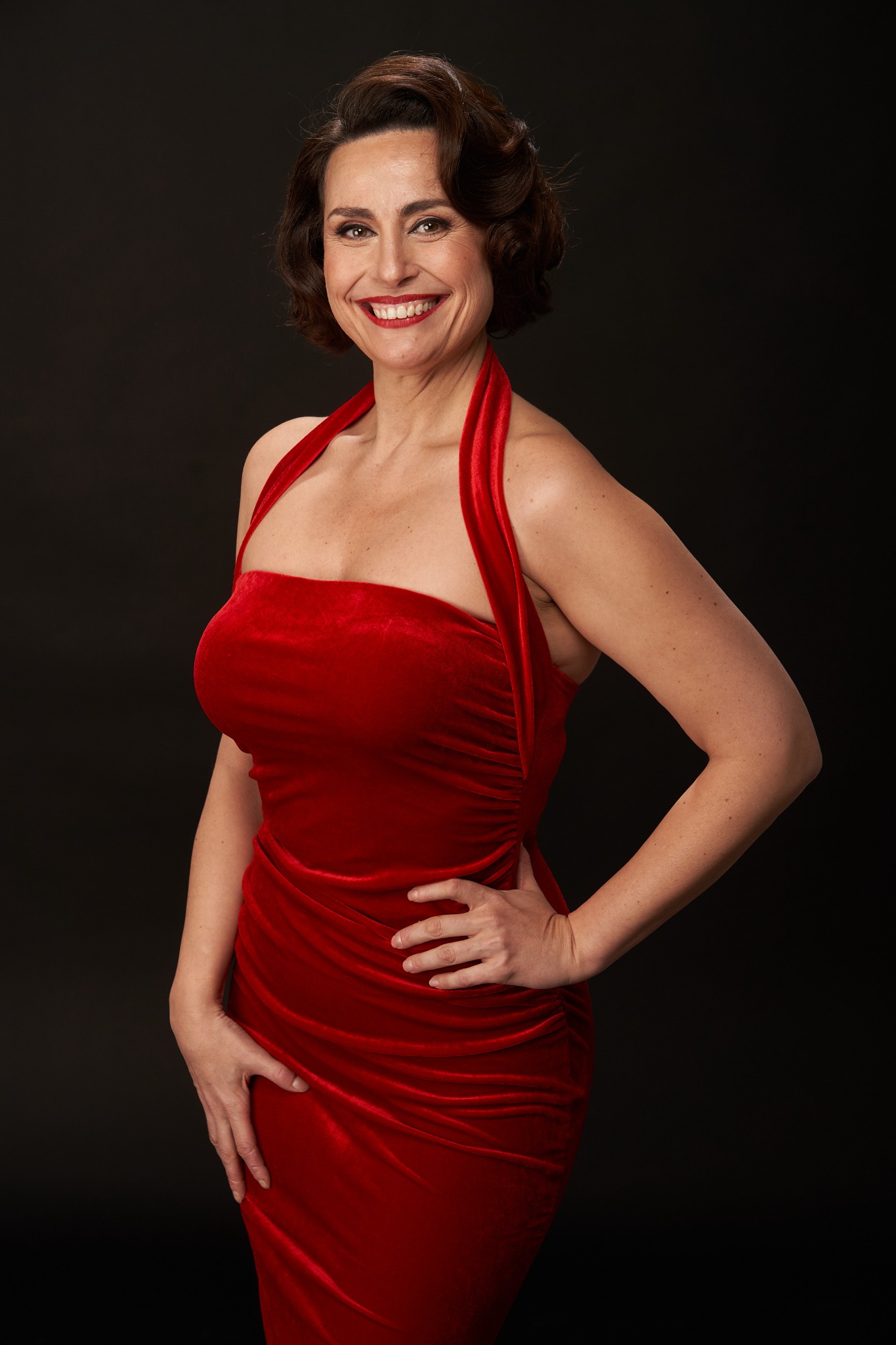 Begoña Álvarez con vestido rojo sobre fondo negro